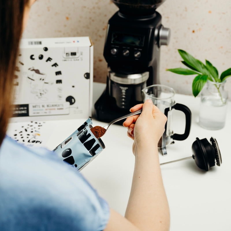 Une femme qui prépare un café de lupin de la marque Lupi Coffee dans une cafetière de piston 